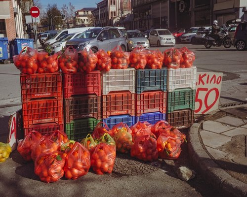 Local Chilean street market called feria libre filled with crates of ripe avocado palta, seasonal red tomatoes, and fresh regional produce