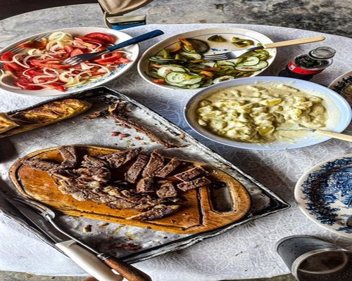 A family preparation of a traditional Chilean lunch with home-cooked beans, salad dressing, and mineral water